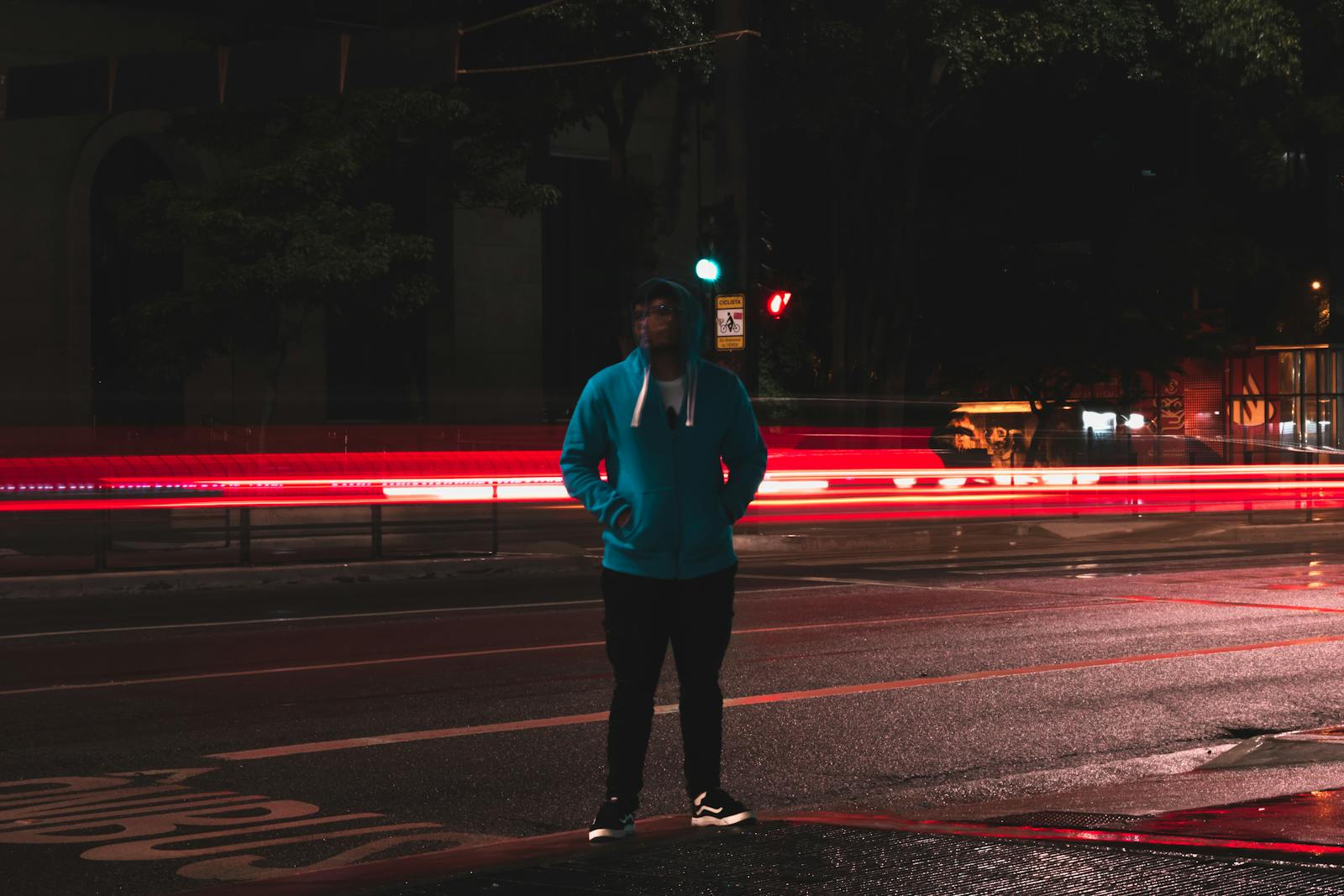 Man standing on empty city road at night