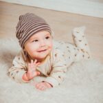 Smiling Baby Lying on White Mat