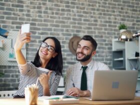 a man and a woman sitting at a table with a laptop