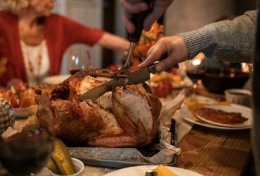 Person Slicing Meat on Table