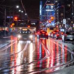 a busy city street at night with cars driving on it